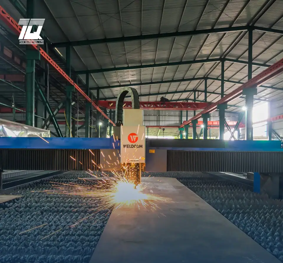 Máy cắt CNC Weldcom đang cắt thép tấm, tia lửa bắn toé trên bàn cắt
