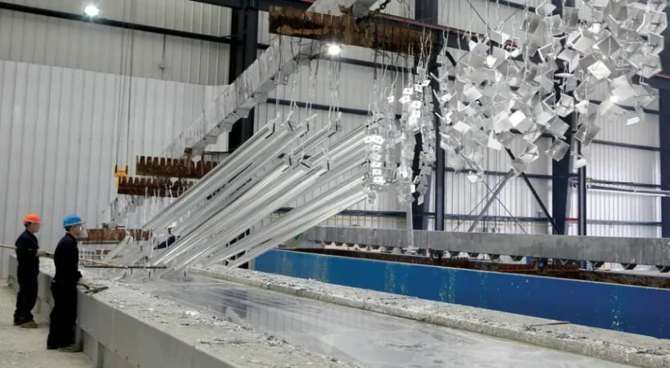 Thép hình và chi tiết thép được nhấc lên khỏi bể kẽm nhúng nóng