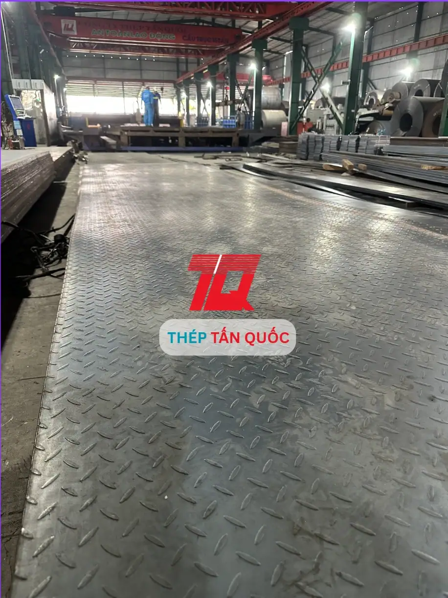 Tấm thép gân chống trượt khổ lớn trải trên bàn tại nhà máy Tấn Quốc